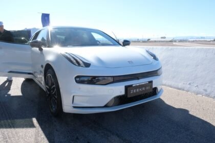 Carros elétricos chineses atravessando uma fronteira simbolizando a entrada no mercado canadense após a redução de tarifas.